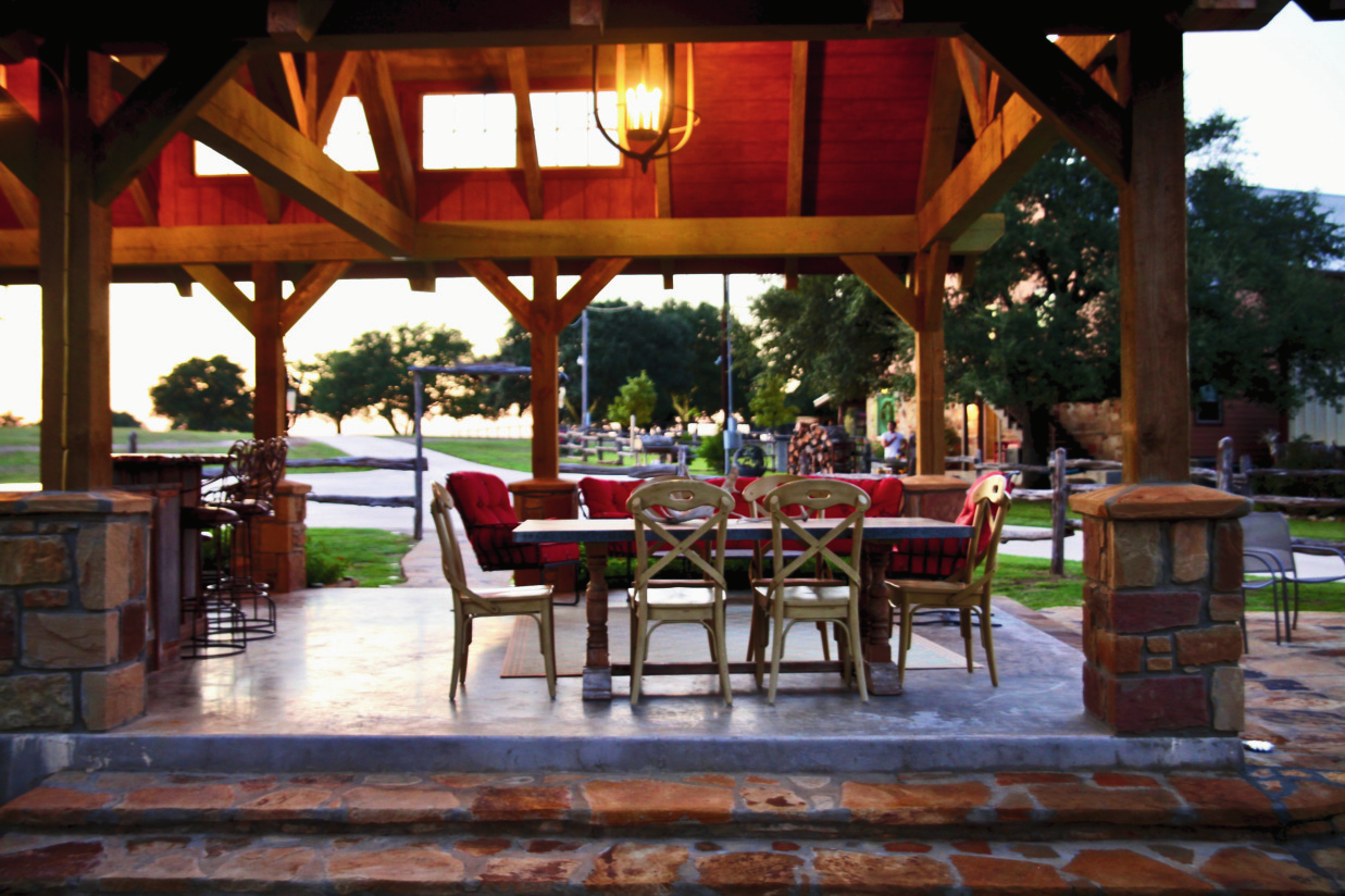 Covered timber pavilion at JDG Ranch with outdoor dining and cushioned seating